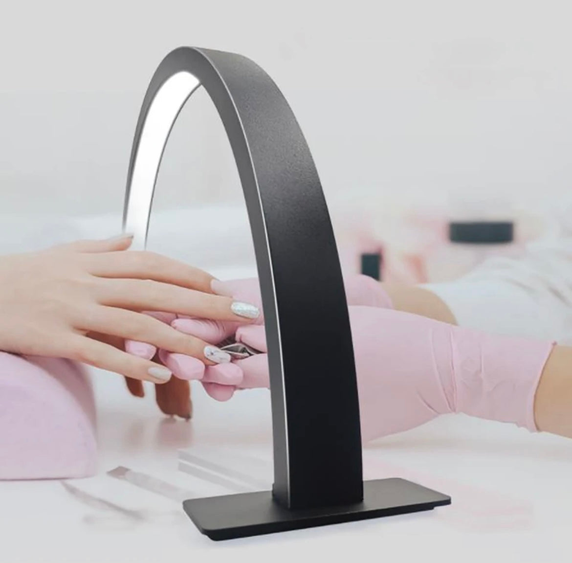 A black Beauty Moon Nail Light with a person's hands placed under the light for nail drying.