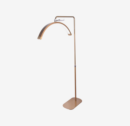 A free-standing gold floor lamp with a curved light fixture, designed for beauty and makeup application.